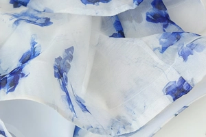 Gros plan du tissu léger de robe avec imprimé floral à l'encre bleue sur blanc