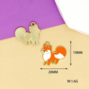 Detail of fox enamel charms showing front orange pattern and gold textured back