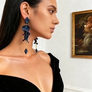 Detail of dark blue petal tassel earrings with gold chain on model in elegant setting