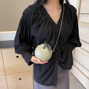 Chic apple-shaped crossbody bag in sage green leather with a gold chain strap