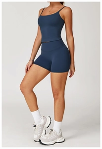 Detailed full-body shot of a woman in navy blue yoga set with dual-strap sports bra