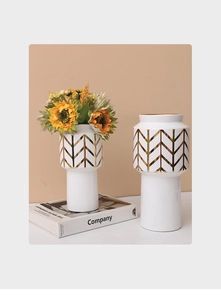 Detail of white ceramic vases with golden chevron patterns and yellow sunflowers