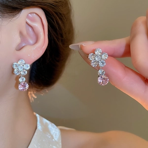 Luxury zircon floral earrings with pink drop pendant on a soft bokeh background