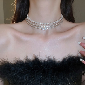 Close-up of a multi-layer pearl choker with sparkling rhinestones on a female model