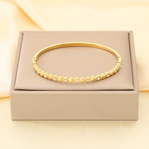 Dettaglio di un bracciale rigido placcato oro 18K con zirconi bianchi su espositore