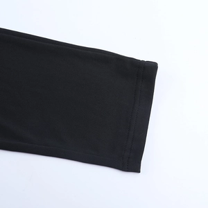 Macro view of double-needle stitching on the black fabric cuff of a long-sleeve jumpsuit
