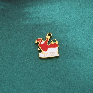 Detail of DIY Christmas pendant featuring Santa on a sled with red and white enamel