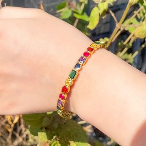 Classic gold open cuff bracelet with geometric rainbow cubic zirconia on wrist