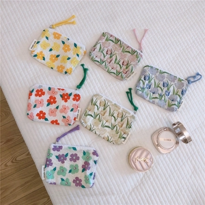 Detailed view of six floral fabric coin purses with zippers and woven handle straps