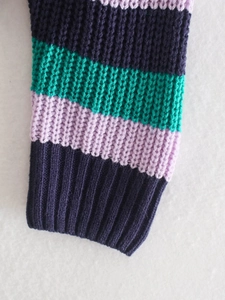 Dettaglio del cardigan in maglia a righe con polsini a coste e trama del tessuto