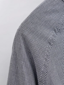 Close-up of shoulder stitching and texture on black and white plaid shirt