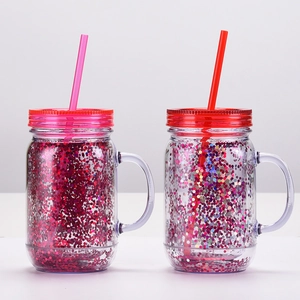 Detail of double-walled glitter mason jars with colorful sequins, handles and straws