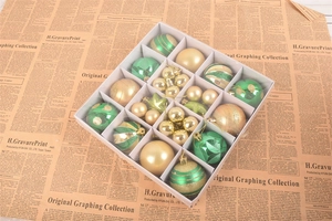 Detail of gold and green Christmas ornaments in a gift box on vintage newspaper