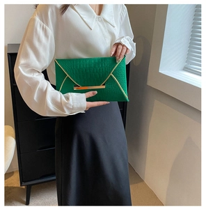 Détail de la pochette enveloppe verte en similicuir brillant avec relief crocodile