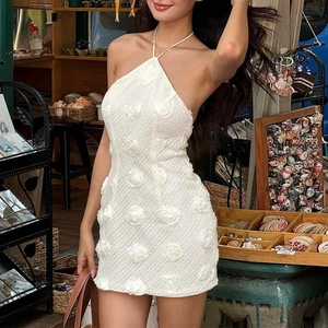 Détail des appliques de roses 3D et de la maille texturée sur la mini robe dos nu blanche