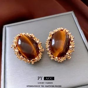 Vintage palace style earrings with oval tiger eye stones and textured gold metal frames