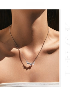 Detail of s925 silver shimmering teardrop necklace on model with elegant shadow effect