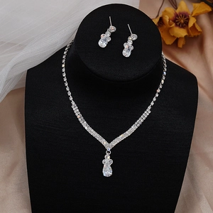 Close-up of bridal V-shape silver jewelry set with zircon tassels on jewelry stand