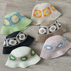 Detailed flat lay of handmade crochet sunflower bucket hats in various vibrant colors