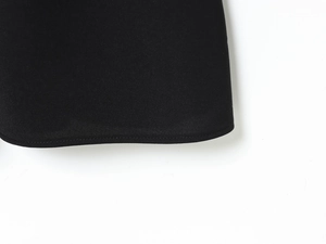 Macro view of black dress hem showing fine stitching and twill fabric texture