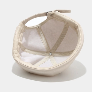 Beige cotton brimless docker hat showing internal six-panel structure and adjustable buckle