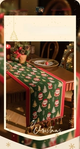 Detailed view of green Christmas table runner with festive tassels and jacquard pattern