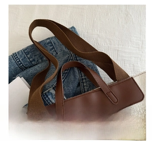 Detail of contrast stripe canvas tote bag featuring brown faux leather handles and strap