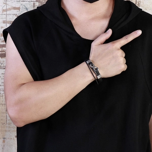 Detail of men's black braided leather bracelet with silver infinity symbol on a male wrist