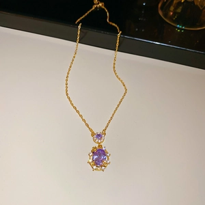 Detail of 18k gold plated necklace featuring an oval purple stone pendant and small crystals