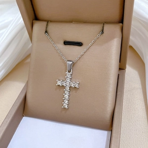 Detailed view of silver cross necklace with sparkling stones in jewelry gift box