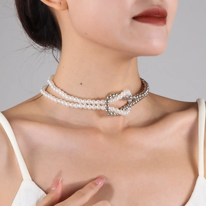 Detail of a layered pearl and silver bead choker necklace worn on a fashion model