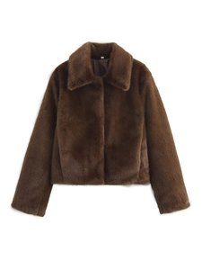 Detail of a dark brown faux fur jacket with a large lapel collar and soft texture