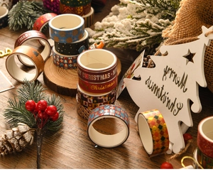 Detailed view of Christmas washi tape with gold foil patterns on wooden table setting