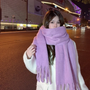 Close-up of soft purple mohair scarf with tassels worn by a model in a city setting
