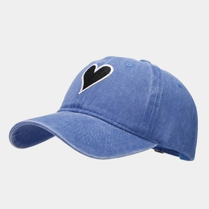 Detail view of heart embroidery patch on vintage washed blue cotton baseball cap