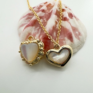 Macro detail of 18K gold plated heart pendant with natural mother of pearl inlay and chain