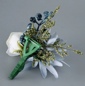 Détail de la pince et de l'épingle en métal au dos d'une boutonnière de rose blanche