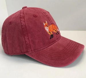 Close-up of pixelated fox embroidery on a vintage burgundy washed cotton baseball cap