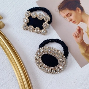 Sparkling crystal rhinestone hair ties in rectangular and oval designs on white marble