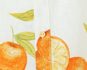 Nahaufnahme von Leinenkleid mit Orangenprint und beigem Knopfdetail aus Baumwollmix