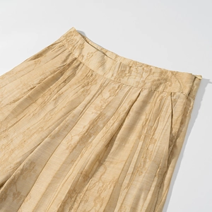 Detail of champagne gold jacquard high waist pants featuring side zipper and pockets