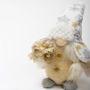 Christmas gnome doll with white snowflake hat and gold flower accent on white background