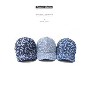 Detailed view of three denim flower baseball caps in dark, medium, and light blue floral fabric