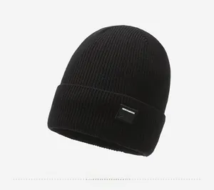 Detailed side view of black knit beanie featuring a mountain patch and clear ribbed texture