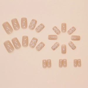Short square press-on nails with sweet pink base and white daisy floral patterns