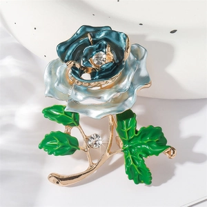 Enameled rose flower brooch with blue gradient petals and rhinestones on a ceramic base
