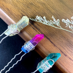 Macro shot of three crystal U-shaped hairpins with yellow, violet, and cyan gemstones