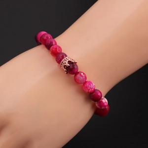 Detailed close-up of 8mm faceted stone bead bracelet with a rose gold crown charm
