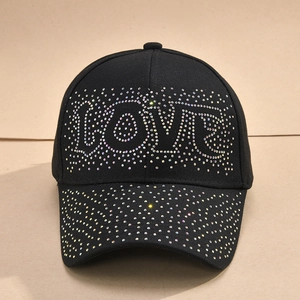 Detailed view of colorful rhinestone LOVE lettering and scattered crystals on a black cap
