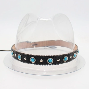 Detail of black leather hat band with turquoise stones and silver metal rivets on white background